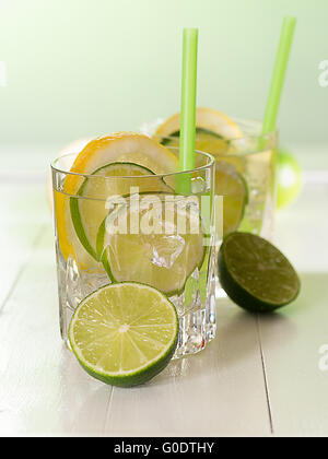 Un verre d'eau avec des limes et des tranches de citron Banque D'Images