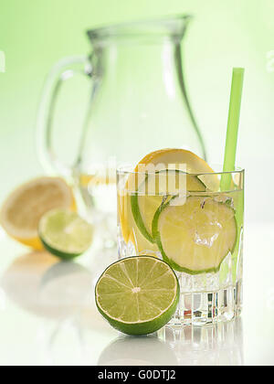 Un verre d'eau avec des limes et des tranches de citron Banque D'Images