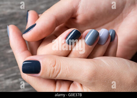 De belles mains avec la miniature peinte dans une couleur gris Banque D'Images