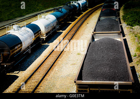 Vue de dessus de voitures de train haute empilée avec du charbon noir sur les voies ferrées le long du côté des wagons-citernes Banque D'Images