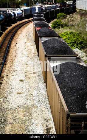 Vue de dessus de voitures de train haute empilée avec du charbon noir sur les voies ferrées le long du côté des wagons-citernes Banque D'Images