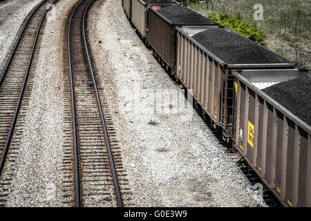 Vue de dessus de voitures de train haute empilée avec du charbon noir sur les voies ferrées le long du côté Banque D'Images