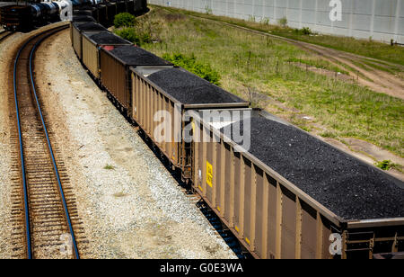 Vue de dessus de voitures de train haute empilée avec du charbon noir sur les voies ferrées le long du côté des wagons-citernes Banque D'Images