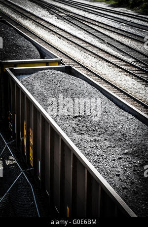 Vue de dessus de voitures de train haute empilée avec du charbon noir sur les voies ferrées le long du côté Banque D'Images