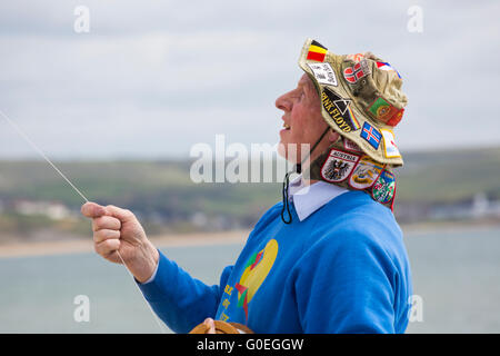 Weymouth, Dorset, Royaume-Uni, 1 mai 2016. Les visiteurs se rendent à la plage de Weymouth pour voir la magnifique exposition de cerfs-volants en vol au festival de Weymouth Kite. Homme senior tenant des cordes cerf-volant cerf-volant portant un chapeau avec des badges. Crédit : Carolyn Jenkins/Alay Live News Banque D'Images