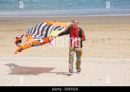 Weymouth, Dorset, Royaume-Uni, 1 mai 2016. Les visiteurs se rendent à la plage de Weymouth pour voir la magnifique exposition de cerfs-volants en vol au festival de Weymouth Kite. Homme en vêtements colorés marchant le long de la plage portant le cerf-volant. Crédit : Carolyn Jenkins/Alay Live News Banque D'Images