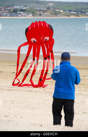 Weymouth, Dorset, Royaume-Uni, 1 mai 2016. Les visiteurs se rendent à la plage de Weymouth pour voir la magnifique exposition de cerfs-volants en vol au festival de Weymouth Kite. Homme au cerf-volant rouge géant. Crédit : Carolyn Jenkins/Alay Live News Banque D'Images