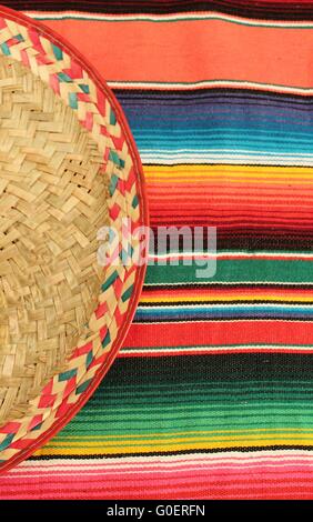 Fiesta Mexicaine traditionnelle poncho tapis de couleurs vives et de l'arrière-plan avec copie espace sombrero Banque D'Images