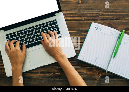 Femme travaillant avec un ordinateur portable placé sur un bureau en bois Banque D'Images