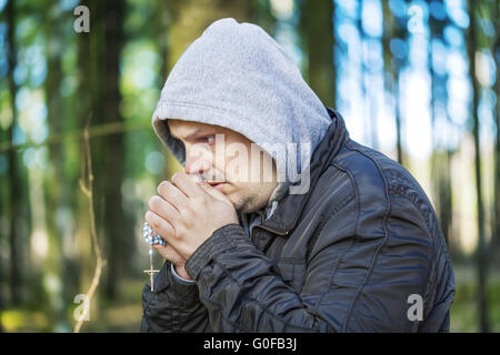 Homme religieux avec un chapelet dans les bois Banque D'Images