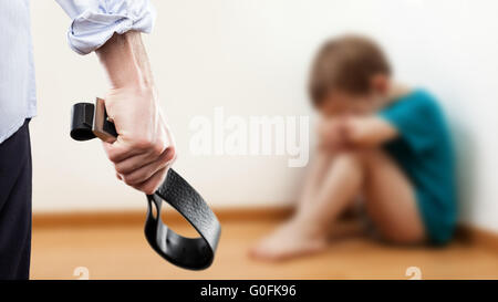 Homme en colère soulevée hand holding ceinture sur enfant garçon Banque D'Images