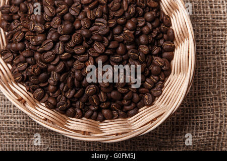 Grains de café dans un panier en osier sur bag Banque D'Images