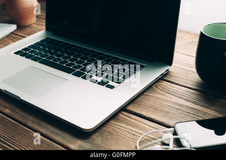 Lieu de travail avec un ordinateur portable ouvert sur un bureau en bois moderne Banque D'Images