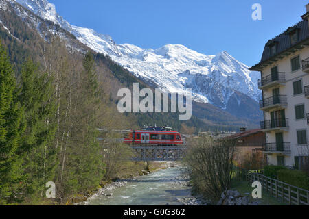 Train touristique sur un pont à chevalet au-dessus de l'Arve et avec le Mont-blanc pour le fond.Chamonix, haute-Savoie, Auvergne-Rhône-Alpes, France. Banque D'Images