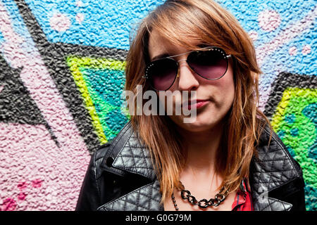 La mode chic girl posing contre mur coloré. Fashion Banque D'Images