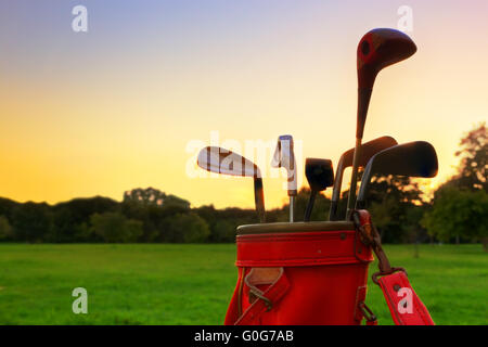 L'équipement de golf. Clubs de golf professionnel dans un bagage en cuir au coucher du soleil Banque D'Images