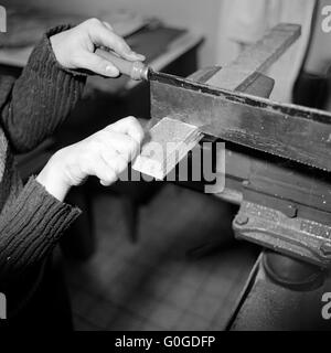 Années 70, photo en noir et blanc, les gens, le handicap physique, l'école, leçons à l'école, l'ouvrage, les mains d'une écolière, scier une planche par une scie, une école spéciale Alsbachtal, Oberhausen, D-D-Oberhausen-Sterkrade, Ruhr, Bas-rhin, Rhénanie du Nord-Westphalie, NRW, Banque D'Images