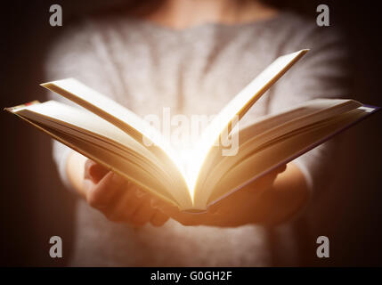 La lumière provenant de réserve en femme# 39;s mains en geste de donner Banque D'Images