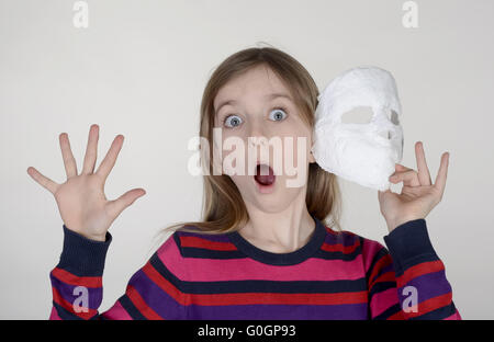 Peur petite fille avec masque en plâtre Banque D'Images