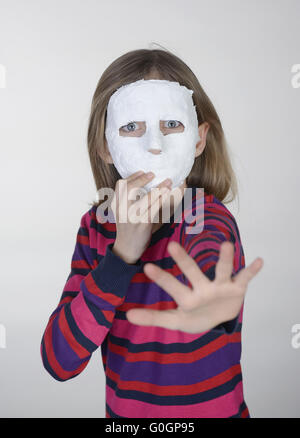 Peur petite fille avec masque plâtre montrant arrêter Banque D'Images