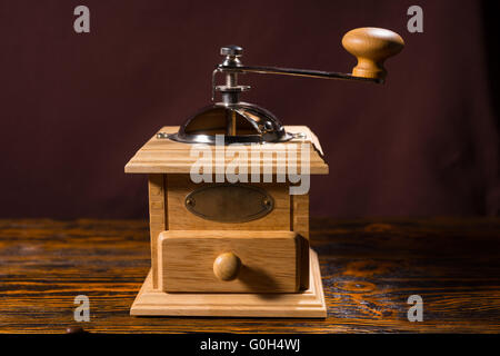 Seul moulin à café en bois avec tiroir et peu plus de manivelle en métal table avec fond sombre Banque D'Images