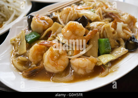 La cuisine chinoise - faire revenir les crevettes avec légumes et champignons. Banque D'Images