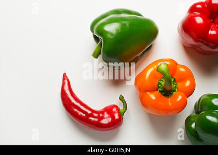 Rouge, vert et orange les poivrons sur fond blanc. Banque D'Images
