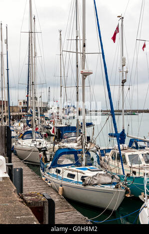 White yachts et autres bateaux de plaisance sont amarrés à leurs couchettes sur une journée nuageuse dans le petit mais très actif port de Weymouth Banque D'Images