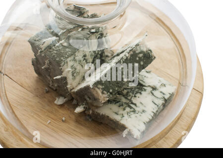 Tranches de fromage blanc moisi de forfaitaire sous couvercle en verre sur plateau en bois isolé sur fond blanc Banque D'Images