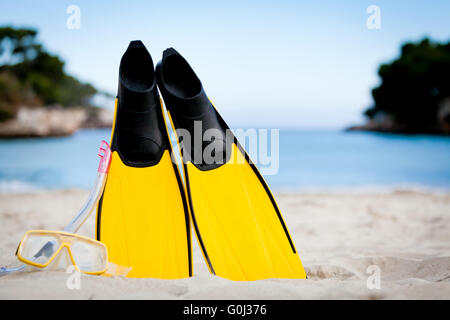 Palmes masque et tuba jaune sur la plage en été Banque D'Images