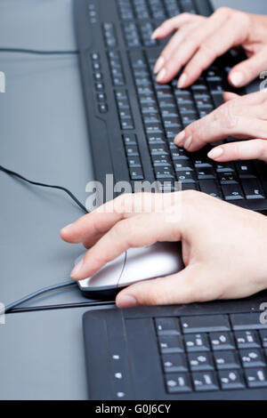 La main sur l'homme pour taper sur le clavier et souris de défilement Banque D'Images
