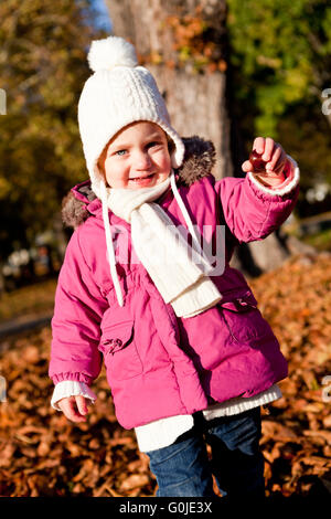 Littloe cute girl playing piscine en automne Banque D'Images