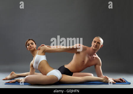Les personnes pratiquant le yoga en paire posing at camera Banque D'Images
