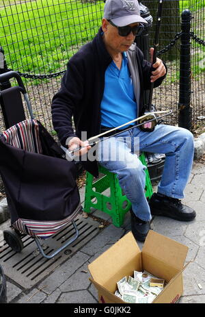 L'homme chinois jouant l'erhu (violon chinois) à Battery Park, New York City, NY, USA Banque D'Images