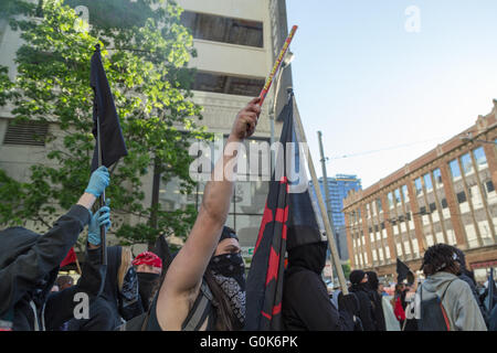 Seattle, USA. 1er mai 2016. Anti-Capitalists Police/manifestants mars, l'un d'eux pousse un pétard dans l'air. Banque D'Images