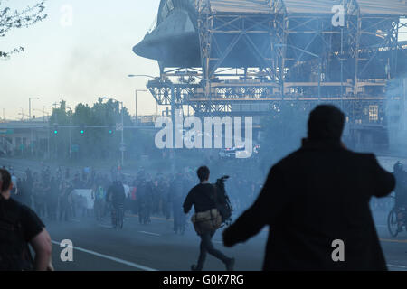 Seattle, WA, USA. 1er mai 2016. Les gens courent dans la rue remplie de fumée après que les agents de police ont répondu à disperser la foule. Banque D'Images