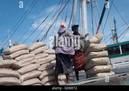 Les travailleurs chargés des sacs de ciment à la coque d'un bateau au port de Paotere à Makassar, Indonésie. Banque D'Images