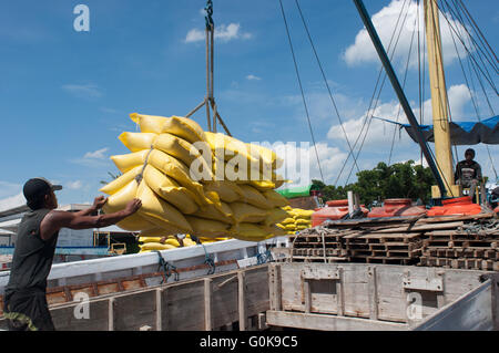 Les travailleurs chargés des sacs de ciment dans la coque d'un bateau au port de Paotere à Makassar, Indonésie. Banque D'Images