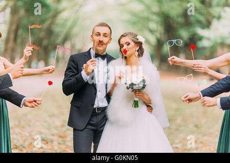 Beau couple marié à fixation papier moustache, lunettes, bow Banque D'Images