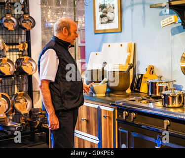 Hauts homme regarde l'affichage de l'équipement de cuisine au magasin dans le vieux Markthalle, Stuttgart, Allemagne Banque D'Images