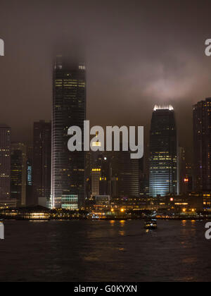 Un et Deux International Finance Centre IFC gratte-ciel dans le centre-ville de Hong Kong s'étendant dans le ciel de nuit de brouillard. Banque D'Images