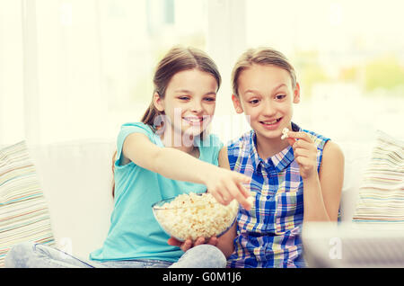 Les filles heureuse avec le pop-corn en regardant la télé à la maison Banque D'Images