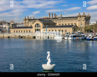 Bouée blanche en forme de garçon et Aduana ancien édifice des douanes dans le Port Vell, Barcelone, Espagne Banque D'Images