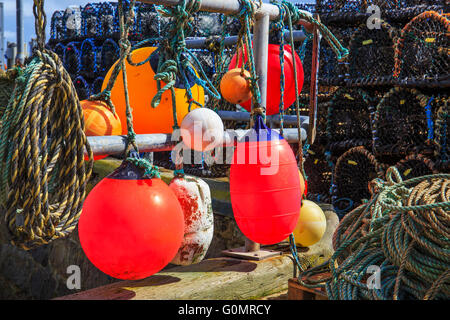 Flotteurs, filets de pêche, des casiers à homard et corde attachée aux mains courantes à Harbourside. Banque D'Images