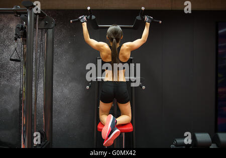 Femme de l'exercice et faire tirer-ups in gym Banque D'Images