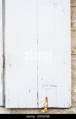 Panneau de fenêtre en bois blanc patiné avec un boulon de métal rouillé. Banque D'Images