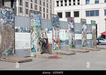 Une partie du mur de Berlin à la Potsdamer Platz en 2016, avec les touristes et un homme habillé comme un ancien soldat allemand Banque D'Images