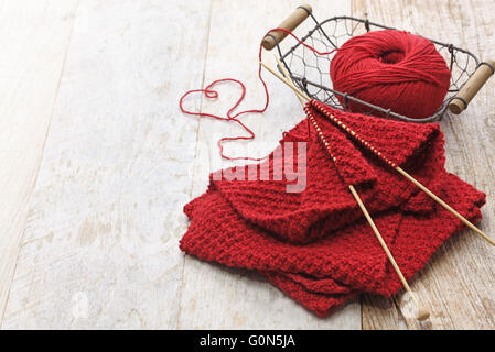 Foulard rouge, tricoté main balle de fils et aiguilles à tricoter pour cadeau de Noël fait main Banque D'Images