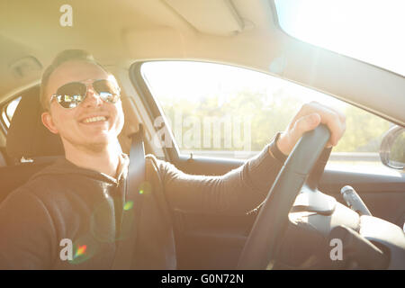 Handsome man driving car le port de lunettes de soleil Banque D'Images