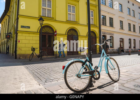 Pologne rue de la ville, vue sur un vélo bleu enchaîné à un poteau de lampe le long de Stolarska dans le quartier de la vieille ville de Cracovie, Pologne. Banque D'Images